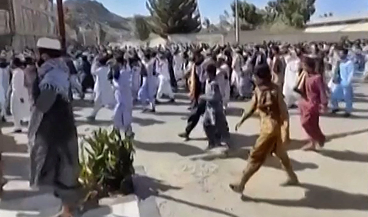 This image grab from a UGC video made available on October 14, 2022, shows Iranian protesters chanting slogans as they march in a street in the southeastern city of Zahedan. (AFP)