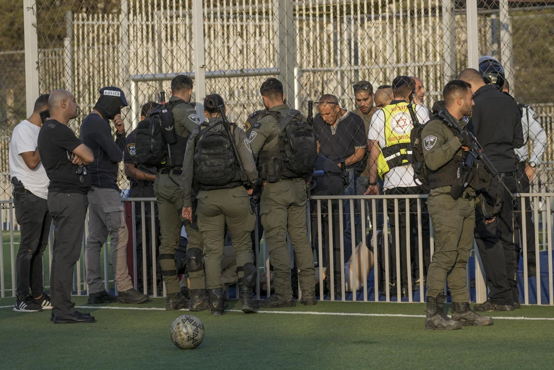 Israeli medics and police treat a Palestinian teen who was shot by police after allegedly stabbing an Israeli in Jerusalem, on Saturday. (AP)