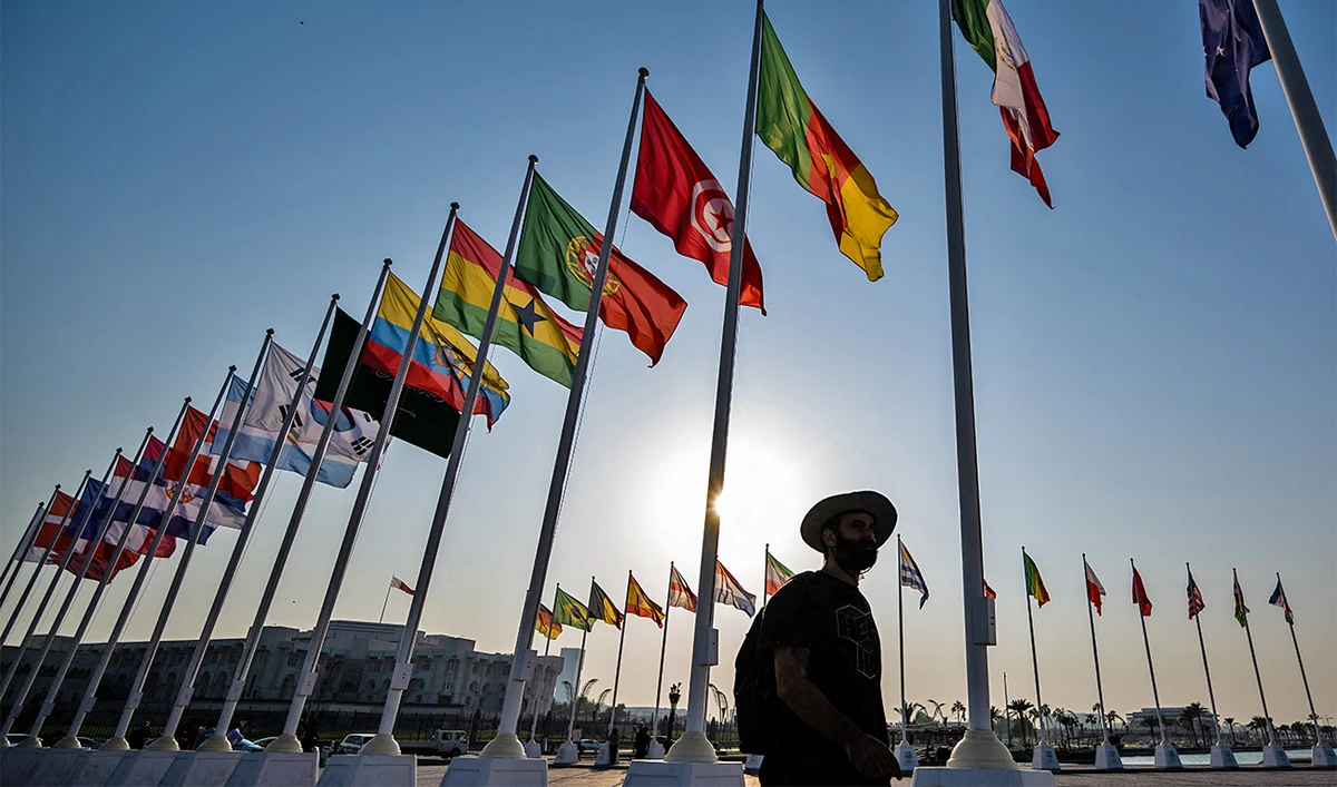 Visitors walk past the flags of the World Cup participating countries in Doha on October 25, 2022, ahead of the Qatar 2022 FIFA World Cup football tournament. (AFP/File)