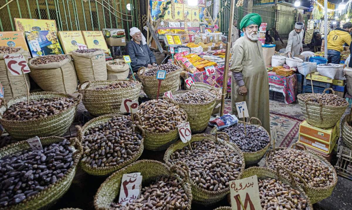 An Egyptian vendor sells dates and dried fruits at a traditional market in Cairo’s central Sayyida Zeinab district. (AFP/File)