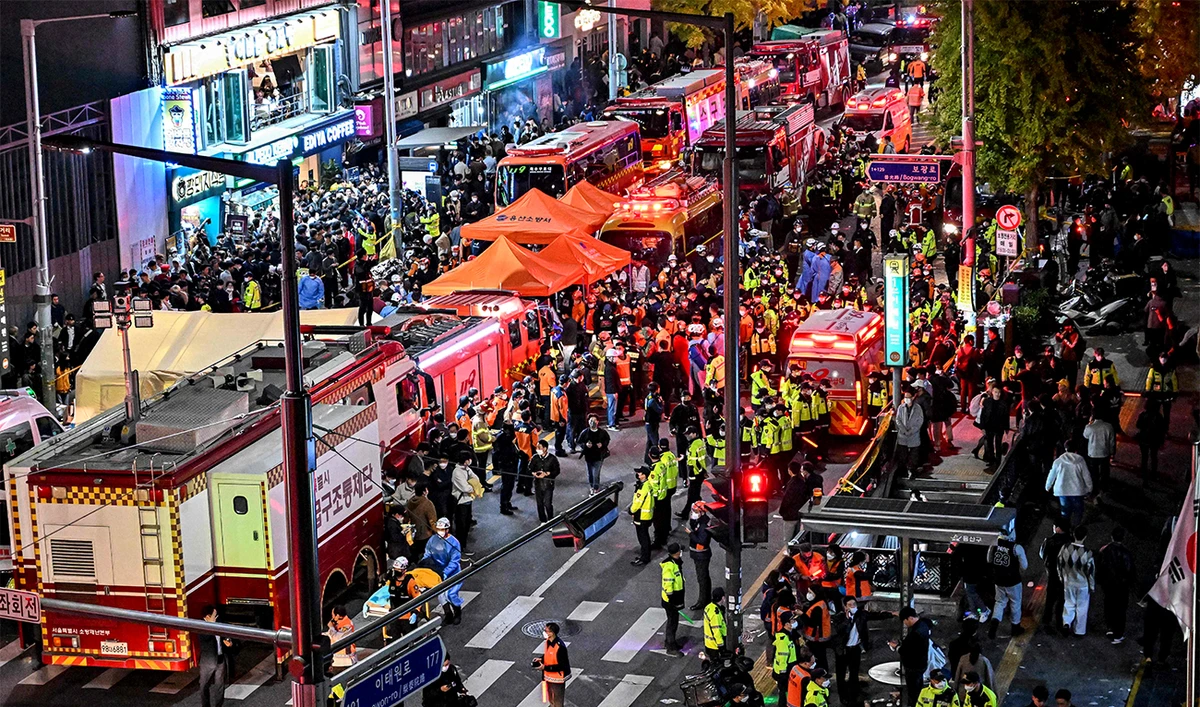 Onlookers, police and paramedics gather where dozens of people suffered cardiac arrest, in the popular nightlife district of Itaewon in Seoul on October 30, 2022. (AFP)