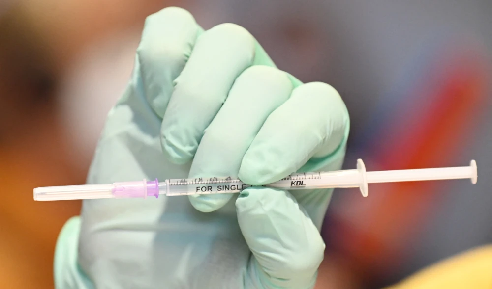 Medical personnel holds a prepared syringe with the Nuvaxovid vaccine against Covid-19 coronavirus. (AFP)