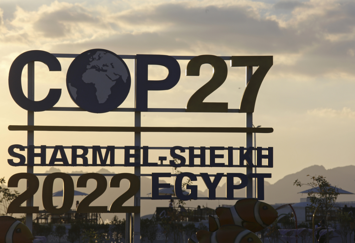 The sun sets behind signage for the COP27 UN Climate Summit in Sharm El-Sheikh, Egypt. (AP)
