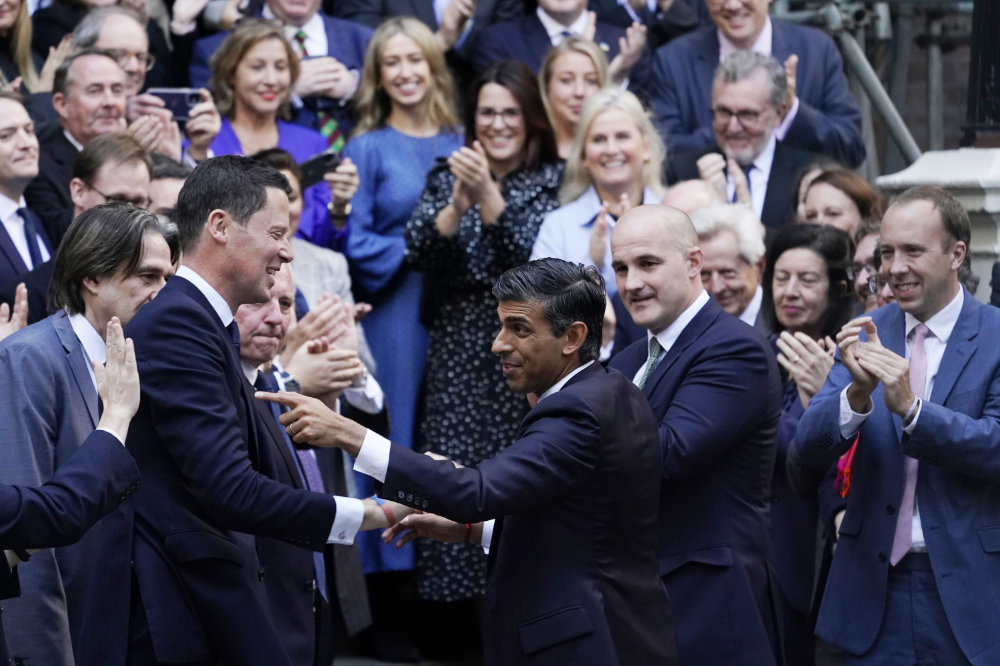 Rishi Sunak, center, gestures as conservative MPs greet him at the Conservative party Headquarters in London. (AP)
