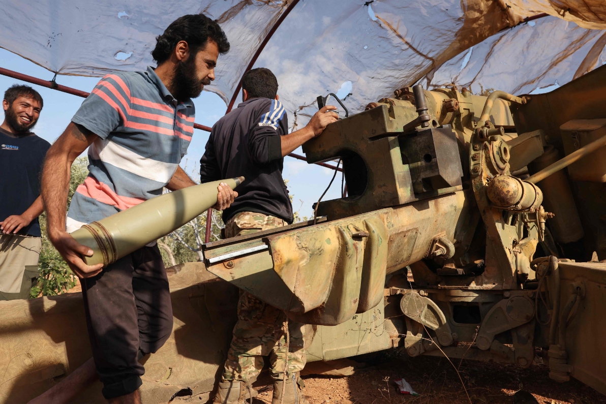 Syrian opposition fighters fire artillery at pro-government forces from a position in the northwestern Idlib province. (AFP)