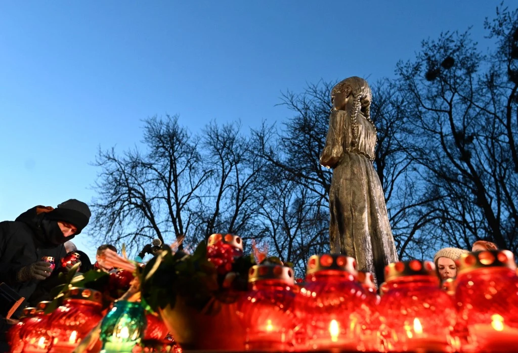 Above, people during a commemoration at a monument to victims of the Holodomor famine of 1932-33 in Kyiv. (AFP file photo)