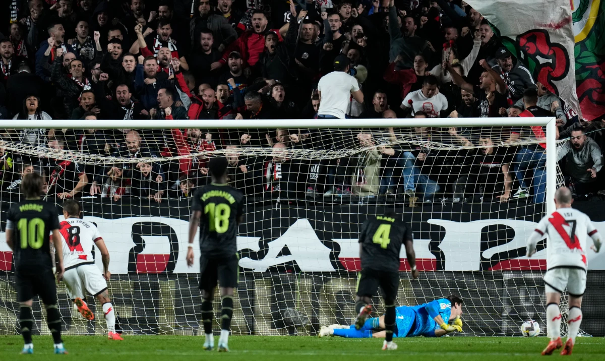 Real Madrid's goalkeeper Thibaut Courtois fails to block a penalty kick shot by Rayo Vallecano's Oscar Trejo, second left, to score his side's third goal during their Spanish La Liga soccer match on Monday. (AP)