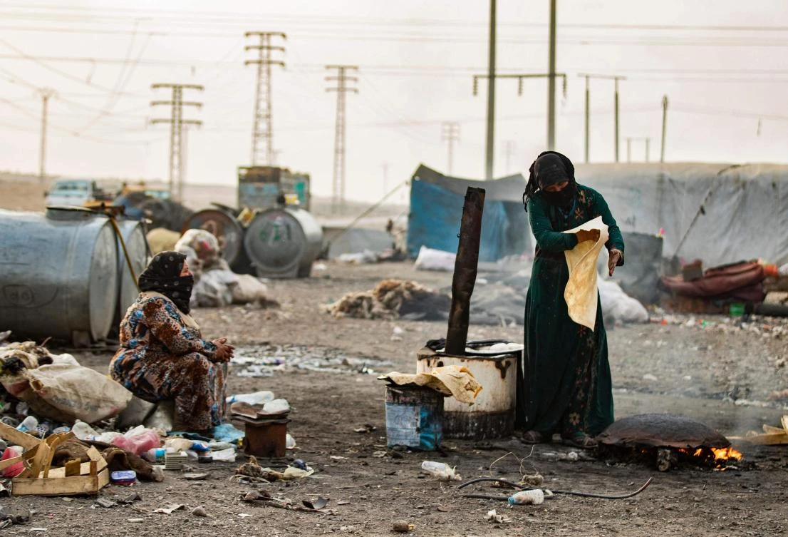 A displaced Syrian woman makes bread at the Sahlah al-Banat camp for displaced people in the countryside of Raqa in northern Syria on November 7, 2022. (AFP)
