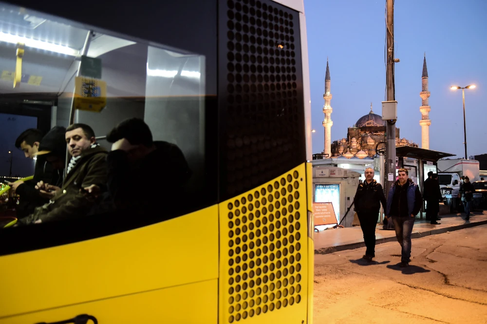 People walk by a bus stop station near the New mosque in the Eminonu district of Istanbul. (AFP file photo)