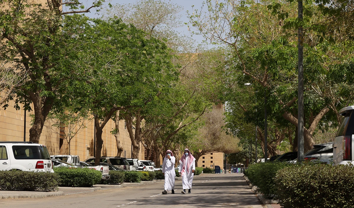 People walk on a tree-lined lane in the Saudi capital Riyadh, on March 29, 2021. (AFP/File)