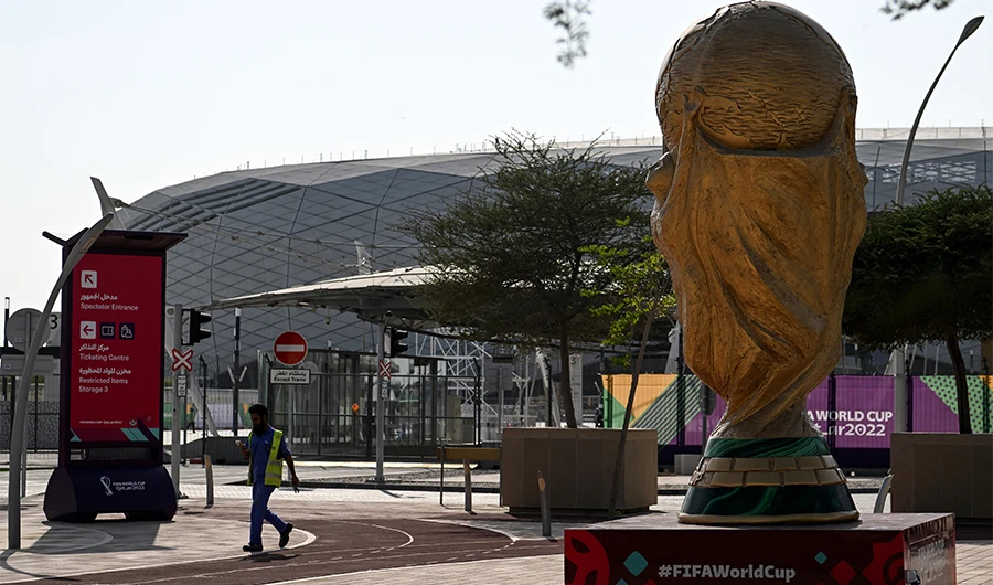 A man walks past a World Cup trophy replica outside the Education City Stadium in Al-Rayyan on November 13, 2022, ahead of the Qatar 2022 World Cup football tournament. (AFP)