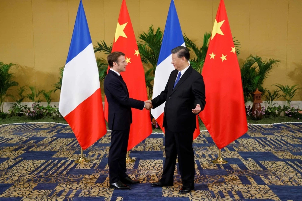 French President Emmanuel Macron (L) shakes hands with Chinese President Xi Jinping prior to their meeting in Nusa Dua, on the Indonesian resort island of Bali. (AFP)