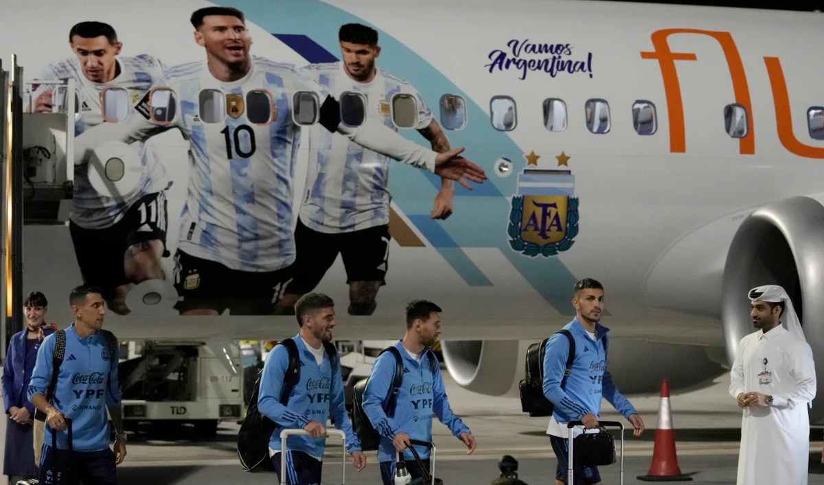 Angel Di Maria, left, and Lionel Messi, second right, of Argentina's national football team arrive with teammates at Hamad International Airport in Doha Thursday, ahead of the upcoming World Cup. (AP)