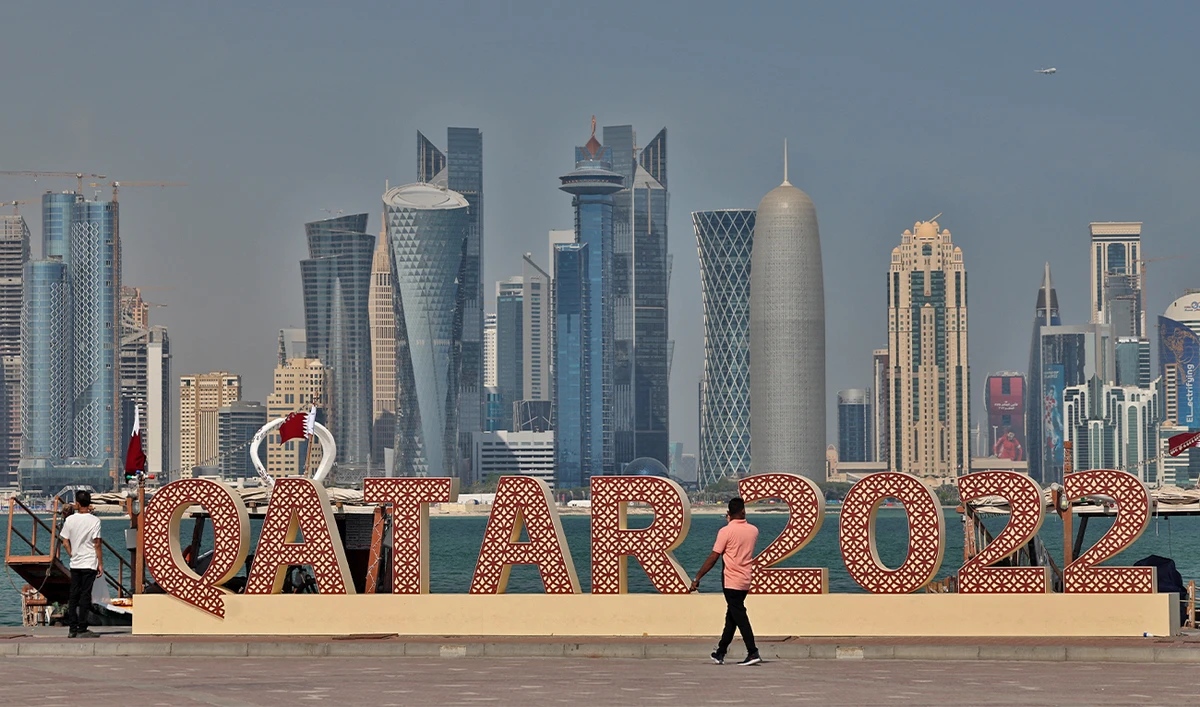 A sign related to the upcoming World Cup is backdropped by the skyline of Doha on November 17, 2022, ahead of the Qatar 2022 World Cup football tournament. (AFP)