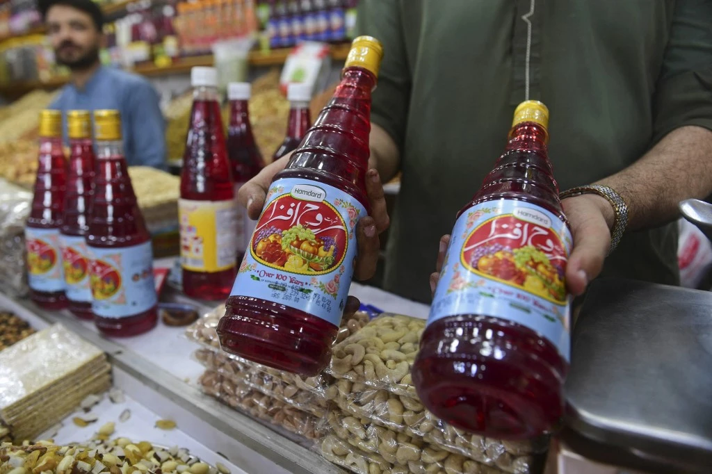 A vendor displays Rooh Afza beverage bottles to customers at a market in Karachi. (File/AFP)