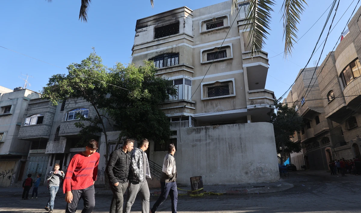 Palestinian men walk past a building where a fire broke out the day before in the top floor apartment, in the Jabaliya refugee camp in the northern Gaza strip, on November 18, 2022. (AFP)