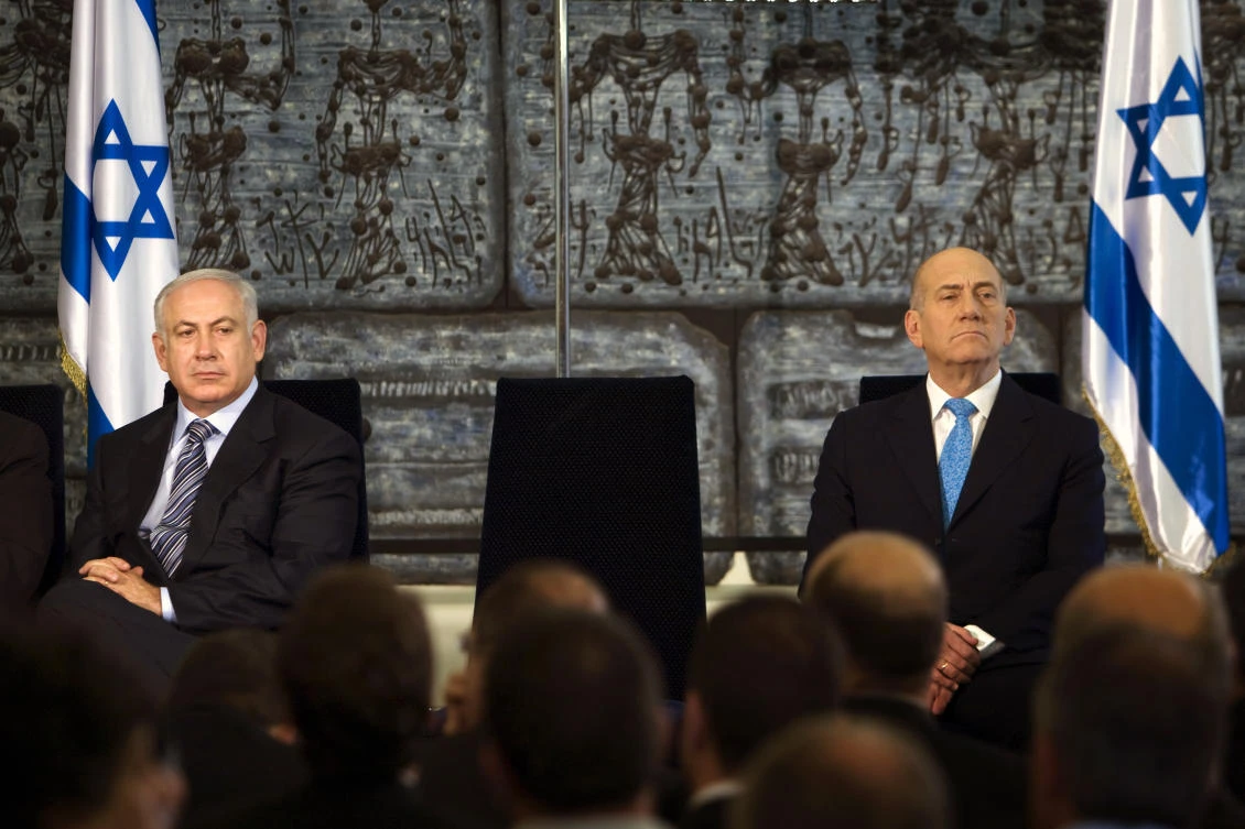 The court ruled that Ehud Olmert’s, right, portrayal of Benjamin Netanyahu, his wife Sara and son Yair had exposed them to hate, ridicule or degradation.’ (AP)