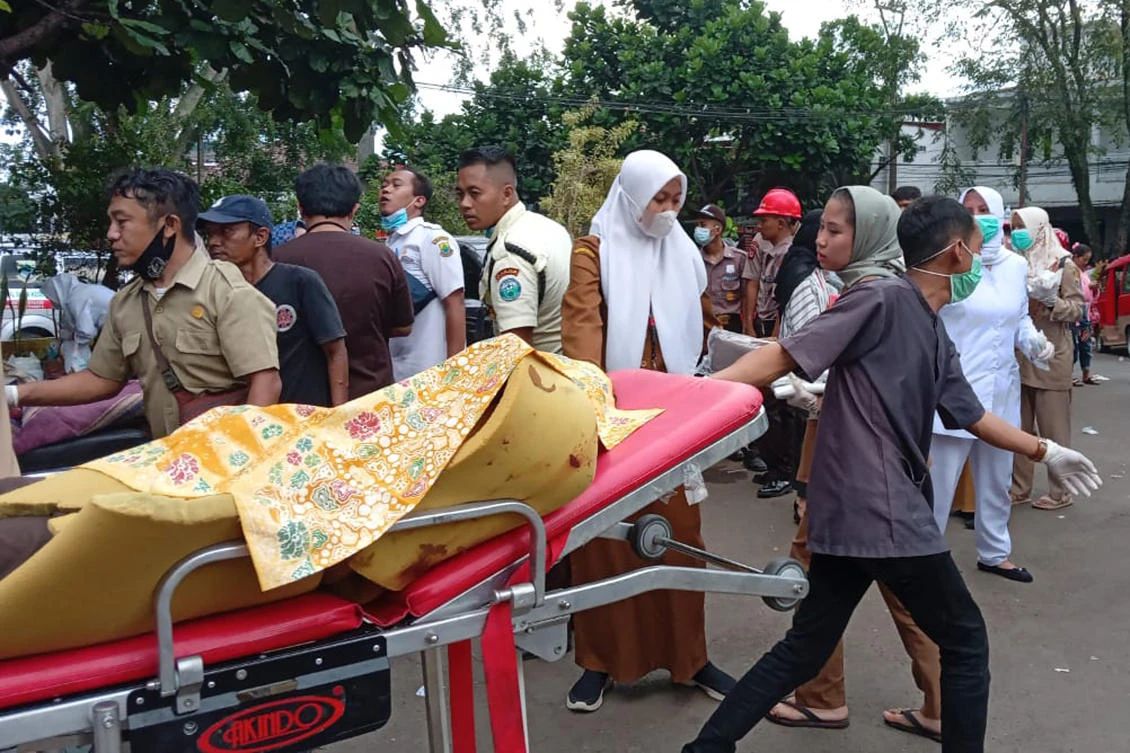 A hospital worker carries an earthquake victim on a gurney outside a hospital in Cianjur, West Java, Indonesia, Monday, Nov. 21, 2022. (AP)