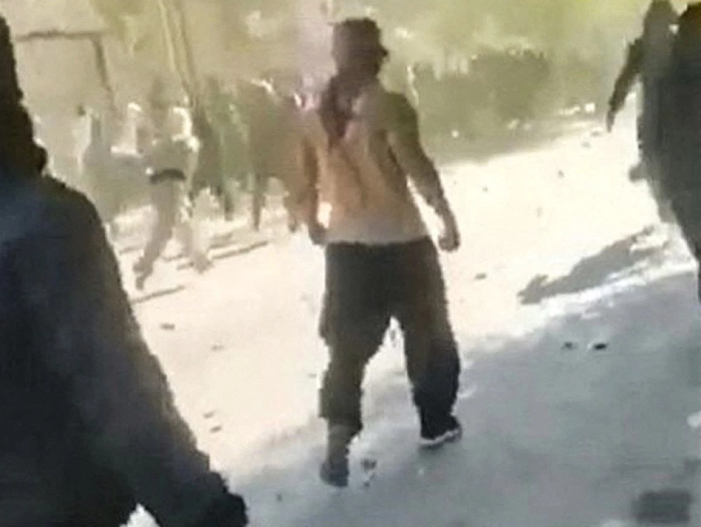 Protesters throwing stones and moving forward amid heavy gunfire on the streets of the Kurdish city of Javanrud. (AFP)