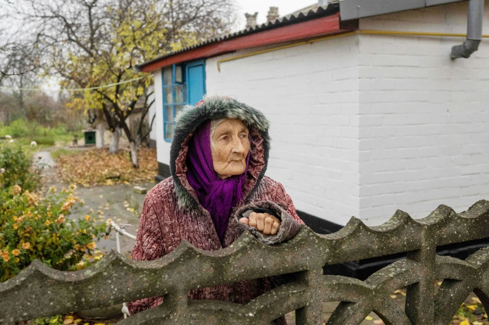 A Ukrainian elderly woman looks out of her garden in the village of Bilozerka, near Kherson on November 20, 2022, amid the Russian invasion of Ukraine. (AFP)