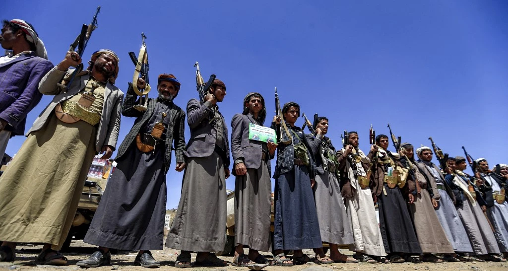 Houthis chant slogans as they hold up Kalashnikov assault rifles during a tribal meeting in Sanaa. (File/AFP)