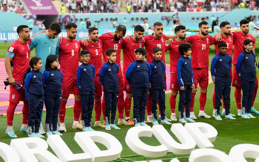The team of Iran standing on the pitch waiting for the national anthem prior to the the World Cup group B soccer match between England and Iran at the Khalifa International Stadium, in Doha on Monday. (AP)