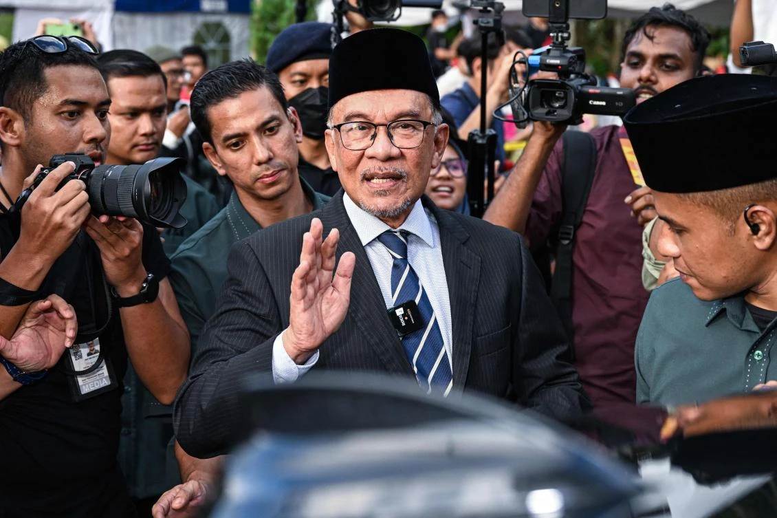 Opposition leader Anwar Ibrahim waves as he leaves after meeting with Malaysia’s King at the National Palace in Kuala Lumpur on November 22, 2022. (AFP)