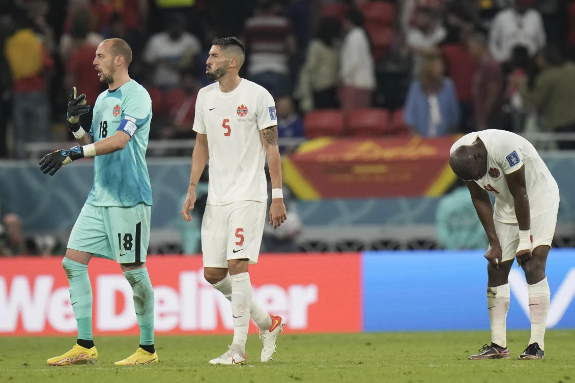 O Canada: Goalkeeper Milan Borjan, left, Steven Vitoria, center, and Kamal Miller react disappointed after losing their World Cup group match against Belgium on Nov. 23, 2022. (AP)