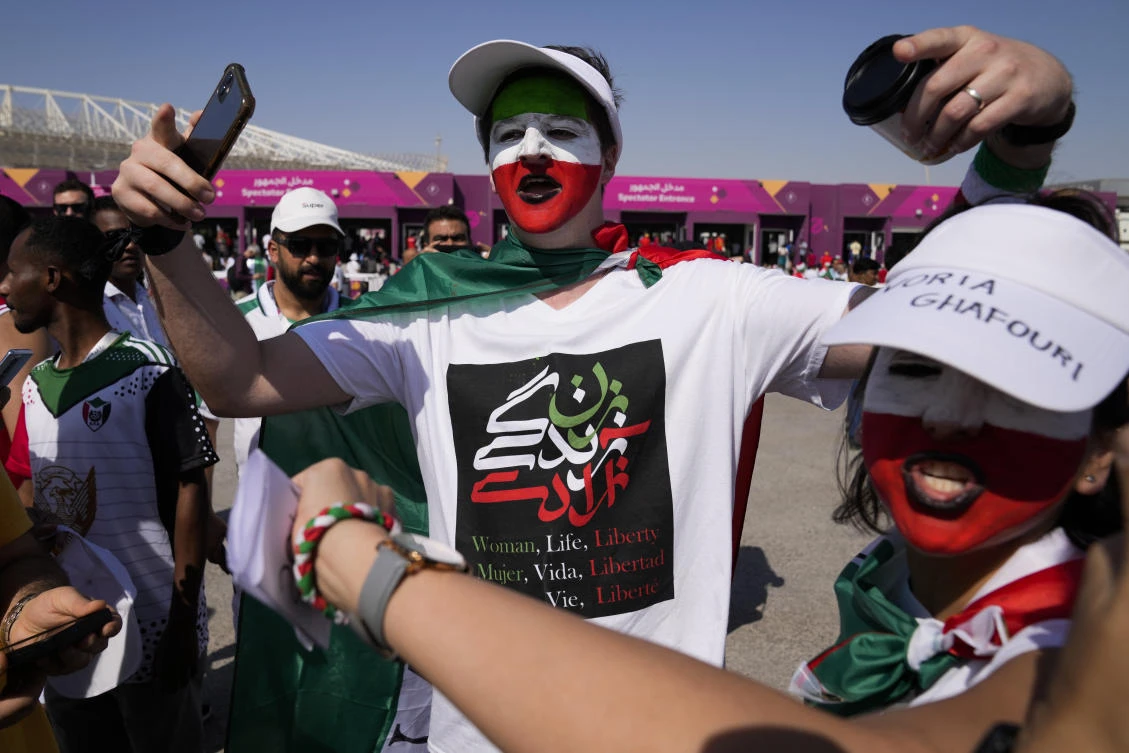 A man, painted in the colors of the Iranian national flag, wears a jersey reading ‘Woman, Life, Liberty’ at Al-Rayyan, Qatar in Nov. 25, 2022. (AP)