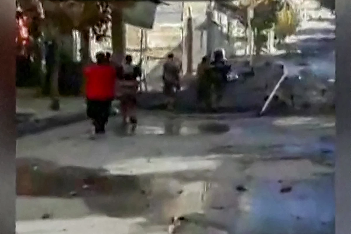This image grab from UGC video footage posted on November 22, 2022 reportedly shows a shooting that took place a day earlier in Iran’s Kurdish city of Javanrud from an apparent security forces’ view as they advance on protesters. (AFP/File)