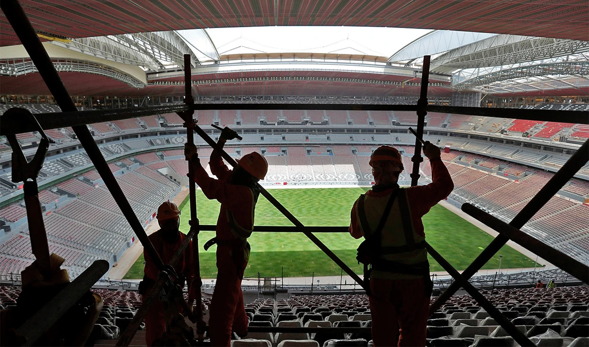 Laborers remove scaffolding at the Al Bayt stadium in Al Khor, Qatar, about 50 kilometers (30 miles) north of Doha, Qatar, on April 29, 2019. (AP)