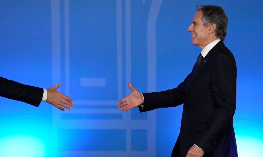 U.S. Secretary of State Antony Blinken reaches to shake hands with Secretary-General Jens Stoltenberg before a family photo in Bucharest, Romania, Tuesday, Nov. 29, 2022. (AP)