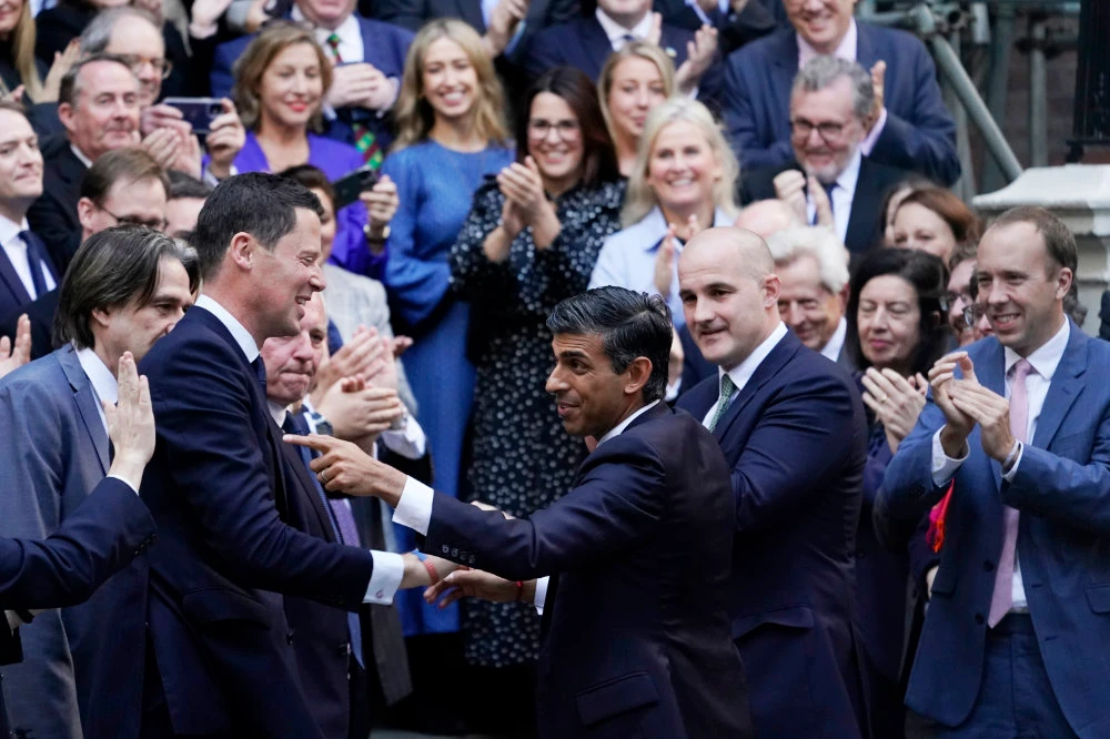 Rishi Sunak, center, gestures as conservative MPs greet him at the Conservative party Headquarters in London. (AP)