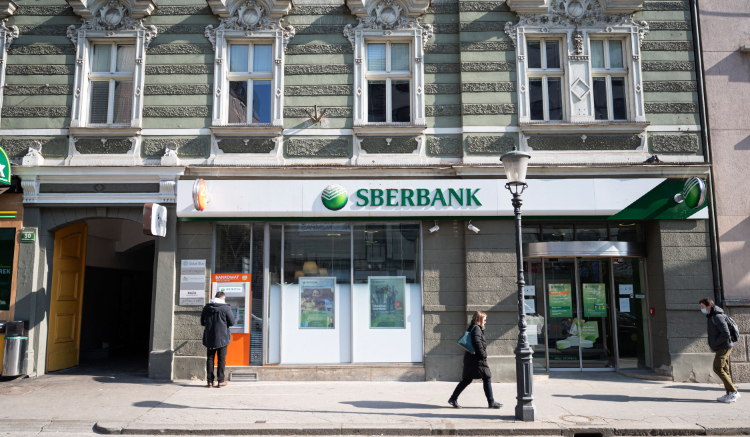 A woman walks past branch of the Russian state-owned bank Sberbank, in Ljubljana on February 28, 2022. (AFP)