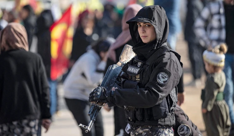 A female member of the Syrian Kurdish Asayish security forces stands in Qamishli in northeastern Syria on Dec. 6, 2022. (AFP)