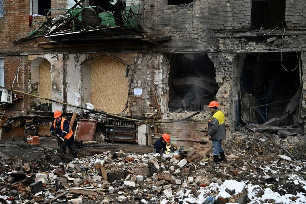 Repairmen work near a residential building damaged following a missile attack in Vyshgorod, outside of Kyiv on Nov. 28, 2022. (AFP)