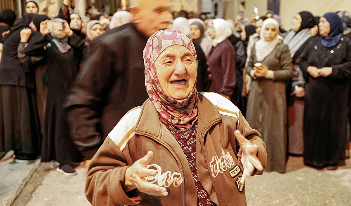 The grandmother of a 25-year-old Palestinian who was killed in clashes with Israeli forces reacts during his funeral. (AFP)