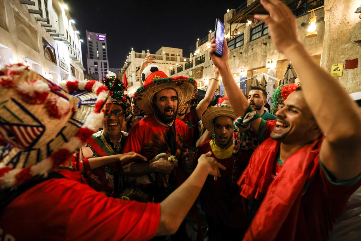 Morocco's supporters celebrate their team's qualification for the next round of the World Cup after their victory in the Group F football match against Canada in Doha. (AFP)