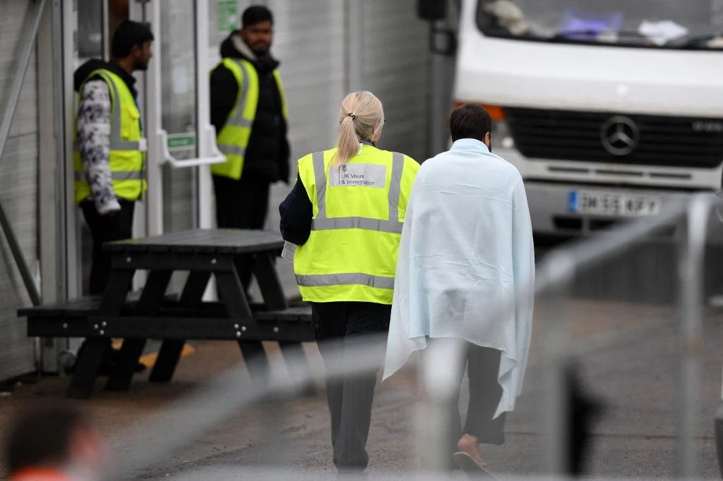 Albanian nationals made up more than one-third of the 33,000 people who crossed the English Channel from January to September this year. Above, a detainee is escorted inside the Manston short-term holding center for migrants. (AFP)