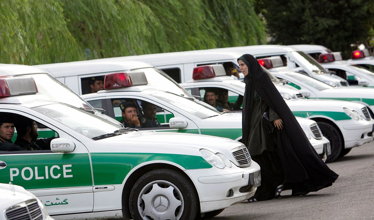 An Iranian policewoman walks between police vehicles, preparing to start a crackdown to enforce Islamic dress code in Tehran, Iran on July 23, 2007. (AFP/File)
