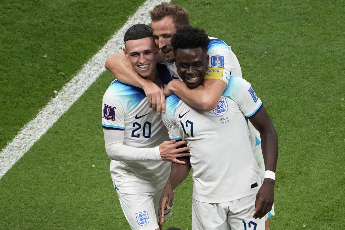 Bukayo Saka, right, celebrates with Phil Foden, left, and Harry Kane after scoring his side’s third goal against Senegal at Al Bayt Stadium in Al Khor, Qatar, Sunday, Dec. 4, 2022. (AP Photo)