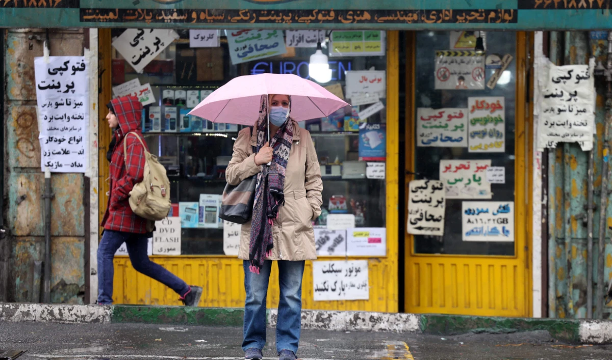 A woman waits for a taxi at Enghelab Square in Tehran on Monday as nationwide protests continued against the regime. (AFP)