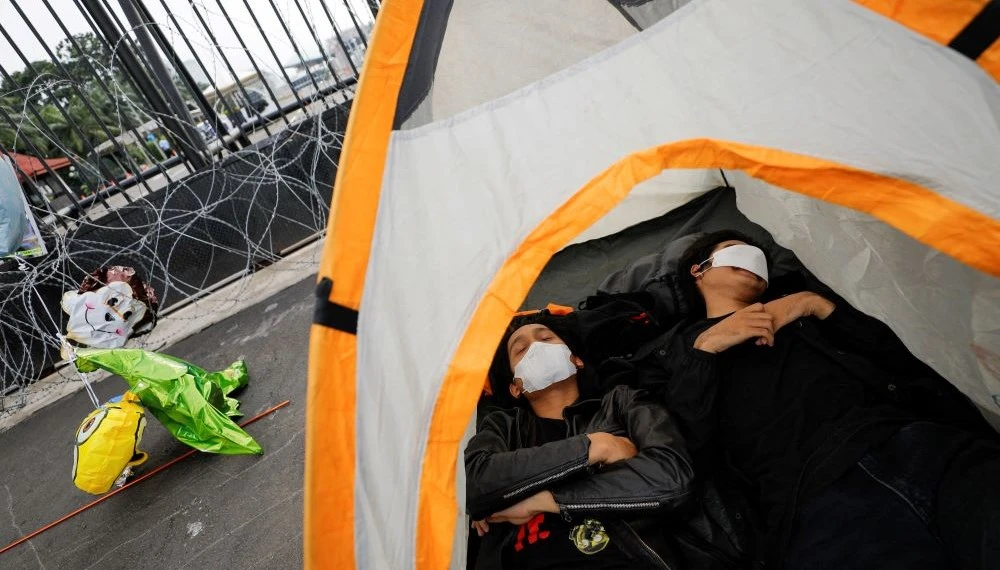 Activists lie inside a tent during a protest after Indonesia’s parliament approved a new criminal code, outside parliament buildings, Jakarta, Indonesia, Dec. 6, 2022. (Reuters)