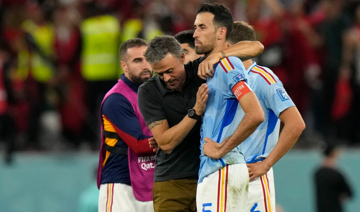 Spain's head coach Luis Enrique, left, embraces Sergio Busquets after the penalty shootout at the World Cup round of 16 between Morocco and Spain, at the Education City Stadium in Al Rayyan, Qatar, Tuesday. (AP)