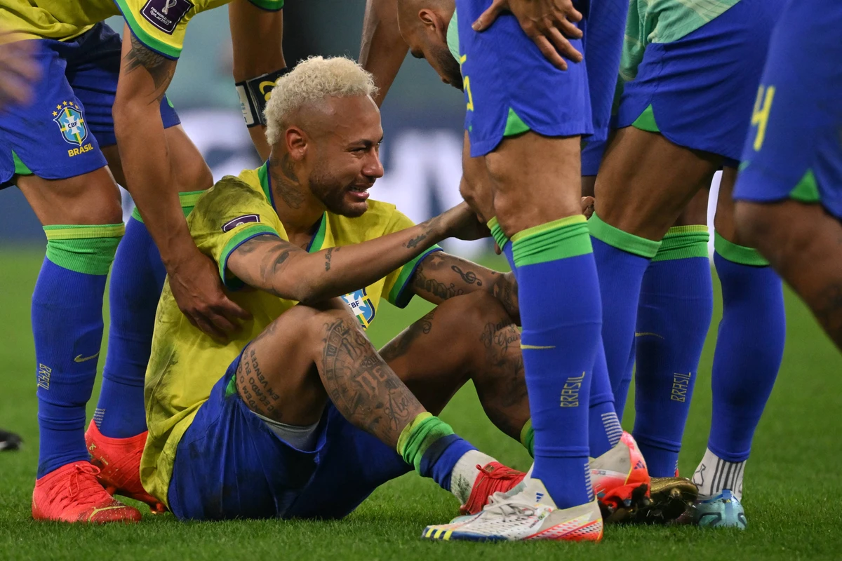 Brazil's forward Neymar is consoled by teammates after they lost Qatar 2022 World Cup quarter-final match against Croatia. AFP
