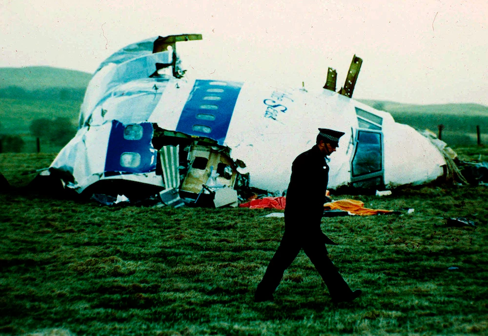 A police officer walks by the nose of Pan Am flight 103 in a field near the town of Lockerbie, Scotland where it lay after a bomb aboard exploded, killing a total of 270 people, Wednesday, Dec. 21, 1988. (AP)