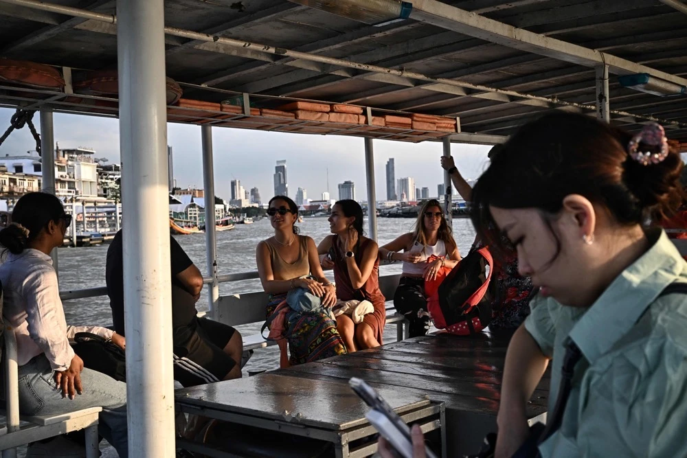 Tourists take a commuter ferry on the Chao Praya River in Bangkok on Friday. (AFP)