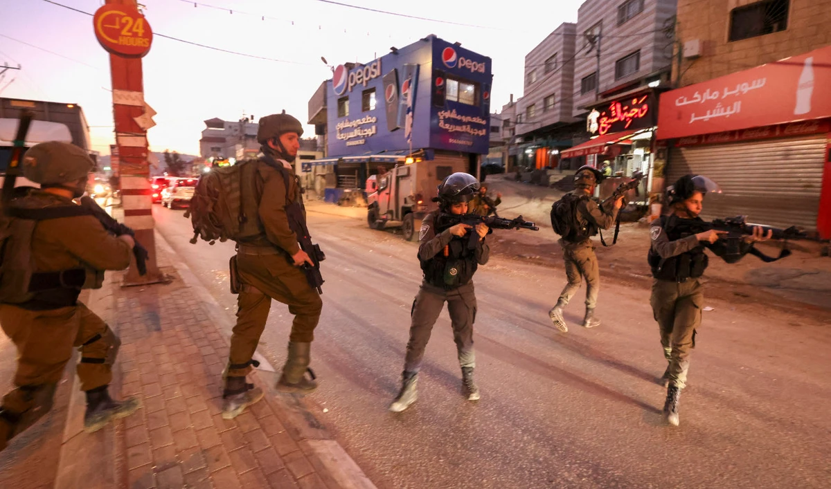 Israeli security forces aim their guns as they deploy in the occupied West Bank city of Hawara on December 2, 2022. (AFP/File)