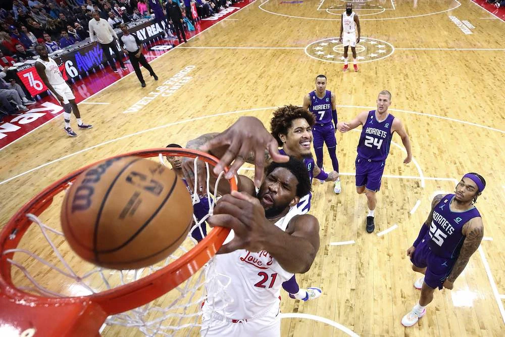 Joel Embiid of the Philadelphia 76ers dunks past Kelly Oubre Jr. of the Charlotte Hornets during the second quarter of their NBA game at Wells Fargo Center on Sunday. (AFP)
