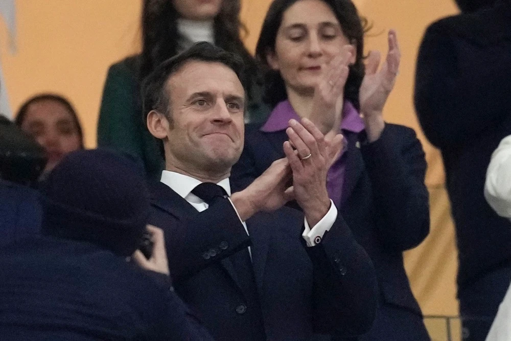 France's President Emmanuel Macron applauds at the start of the World Cup semifinal soccer match between France and Morocco at the Al Bayt Stadium in Al Khor, Qatar. (AP)